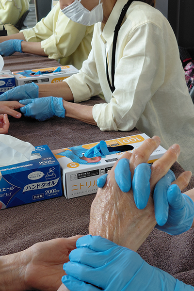 癒やしのハンドセラピー体験で来場者の手に触れるセラピストの手元