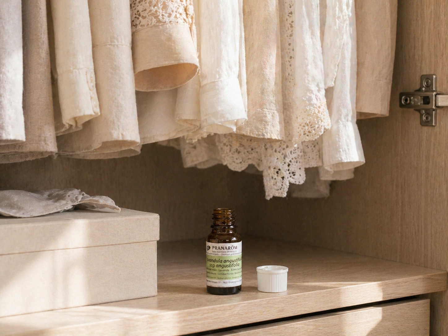 クローゼットの中に置かれた精油の空き瓶とナチュラルな洋服