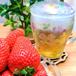 いちごとハーブティーが入った花の絵柄のグラス