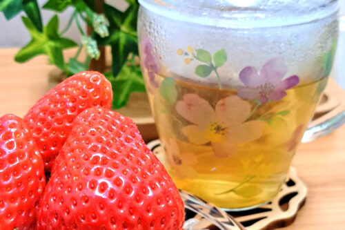 いちごとハーブティーが入った花の絵柄のグラス