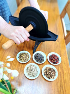 薬研を使って丁寧にハーブを挽くセラピストの手元